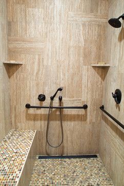 a bathroom with tiled walls and flooring next to a stand up shower stall in the corner