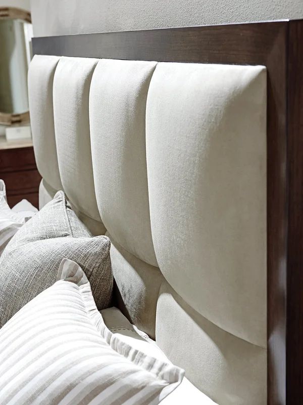 the headboard of a bed with white sheets and pillows