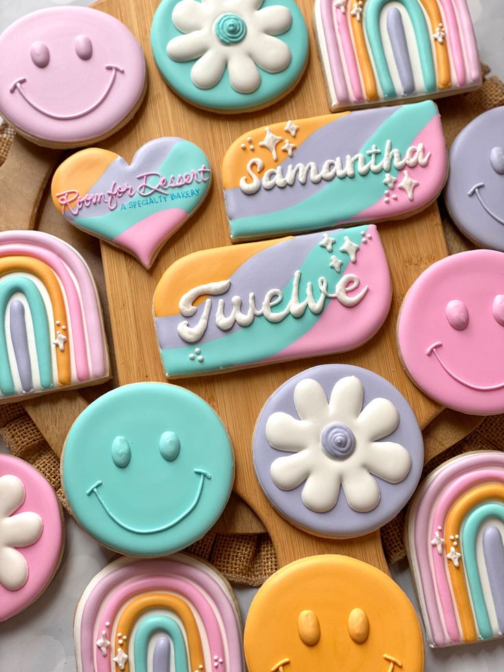 decorated cookies are arranged on a wooden board