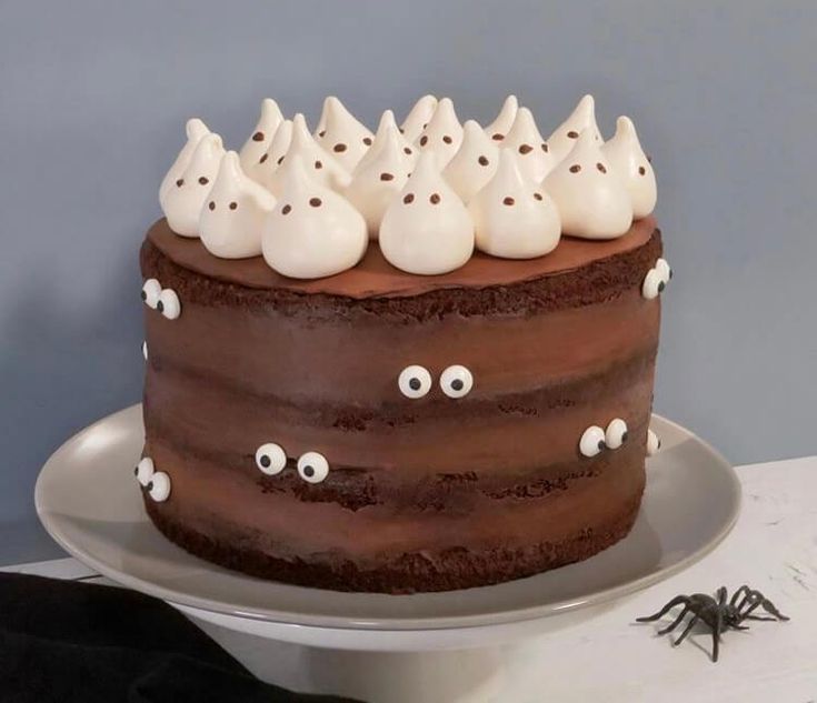 a chocolate cake topped with white frosting and ghost eyes on top of a plate