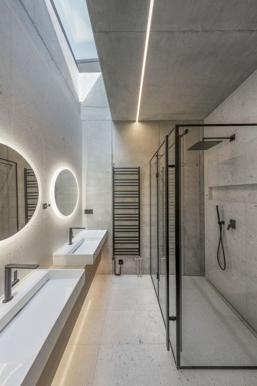 a bathroom with two sinks, mirrors and lights on the wall next to each other