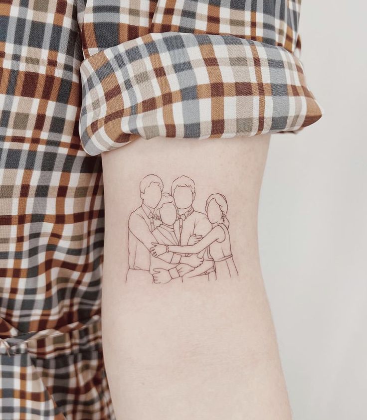 a woman's arm with a small tattoo of two people hugging each other on it