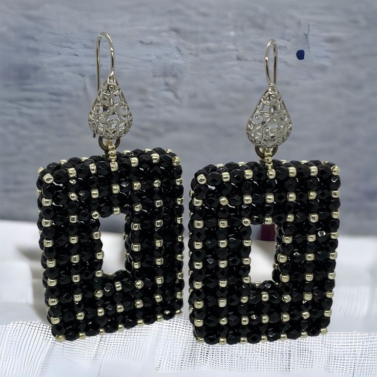 Dramatic black rectangle statement earrings with silver accents.  These beaded earrings are one of a kind, handmade, unique and real  head- turners! Made with high quality Czech facettes and permanent finish silver Japanese seed beads. Permanent finish means they don't tarnish or lose their color. Finished with a silver coloured stainless steel filigree wire earring.  Every item I design is made with the best quality beads, accessories and materials and comes in a handmade embroidered jewellery bag.  Total length: 6,5cm Length drop:  4 cm Width: 3.3 cm Depth:   8 mm Weight (per pair):  22 gr Other colour variations are available in my shop. Handmade Beaded Drop Earrings For Evening, Handmade Drop Earrings For Evening, Unique Black Earrings For Evening, Black Beaded Evening Earrings, Black Handmade Earrings For Evening, Black Beaded Earrings For Evening, Elegant Black Earrings With Silver Beads, Handmade Black Earrings For Evening, Handmade Black Evening Earrings