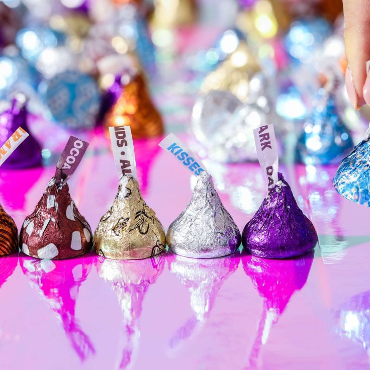 there are many different types of candies on the table with their name tags in front of them