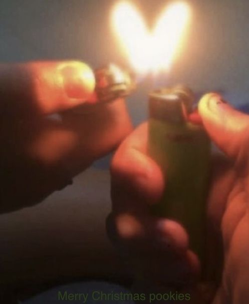 someone holding a lighter in their hand with a heart shaped light on top of it