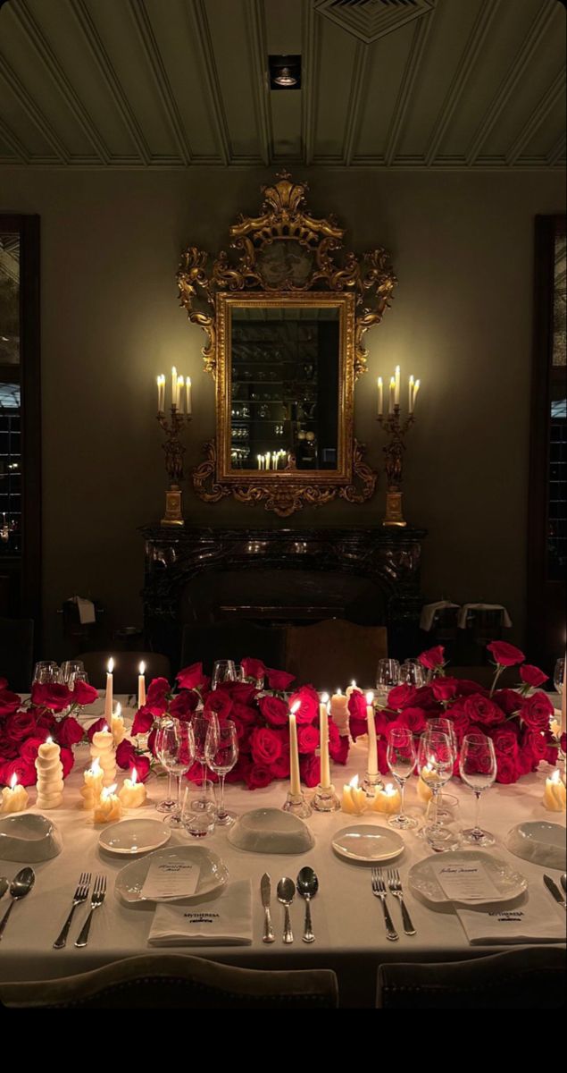 the table is set with candles, plates and silverware for an elegant dinner party