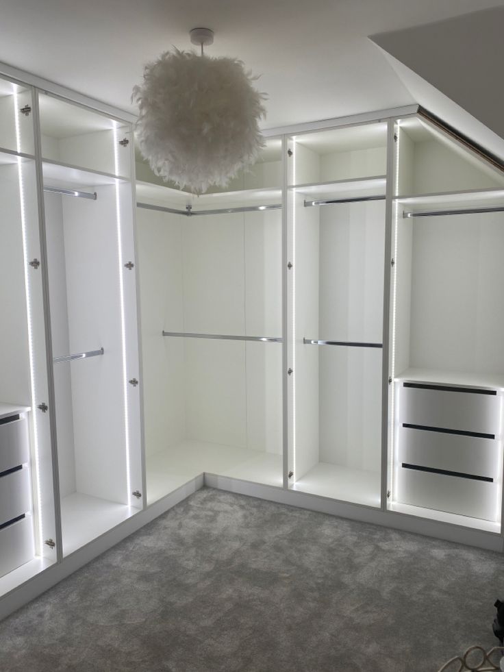 an empty room with white closets and lights