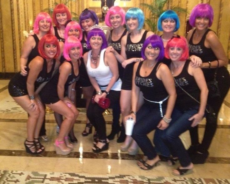 a group of women with pink and blue hair posing for a photo in front of a hotel lobby