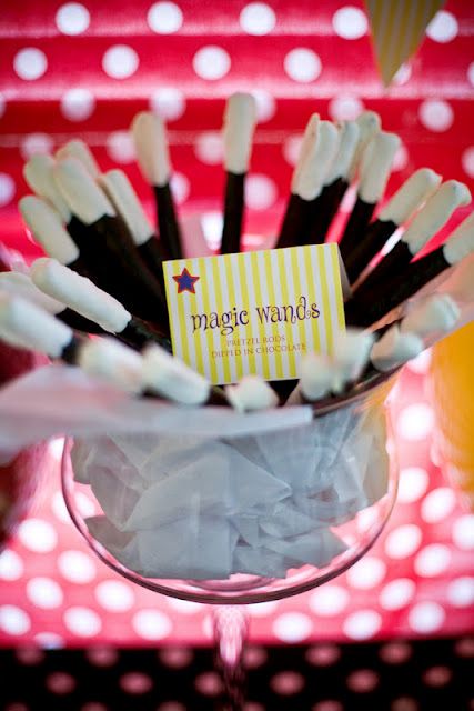 a glass filled with lots of black and white straws on top of a table