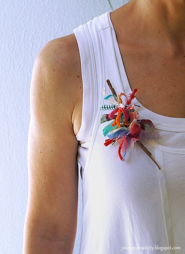 a woman wearing a white tank top with colorful flowers attached to the back of it