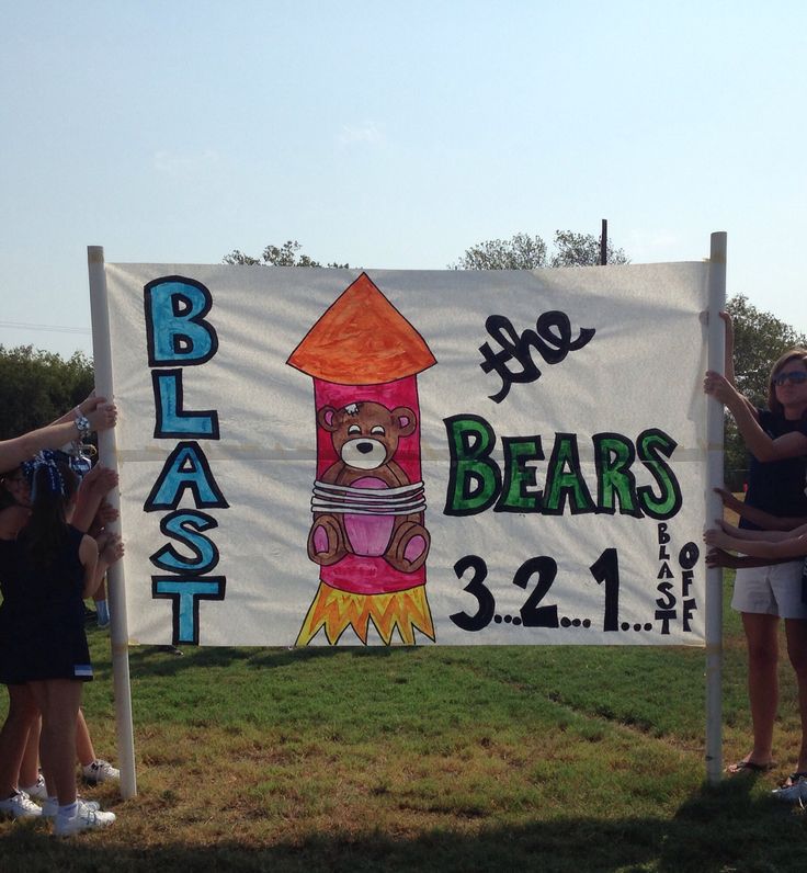 two women standing next to a sign that says blast the bears