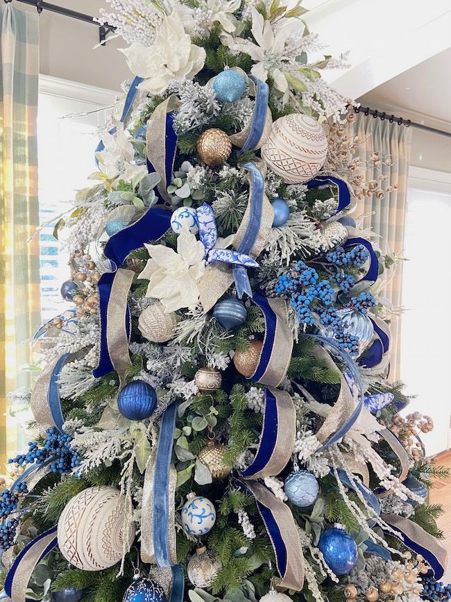 a decorated christmas tree with blue and white ornaments