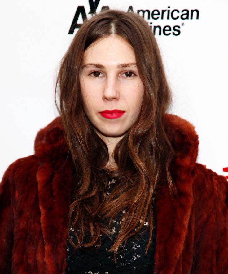 a woman with long hair wearing a fur coat