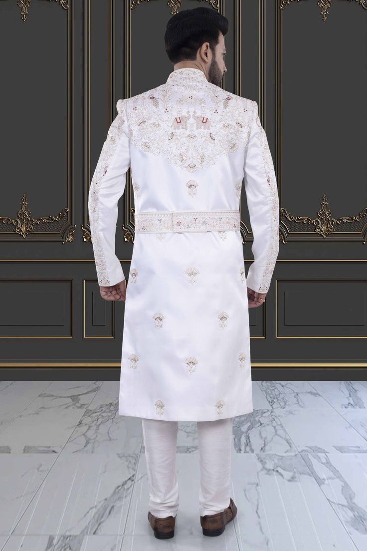 Introducing the V20-S45 Mens Sherwani, adorned with intricate peacock and elephant embroidery. This stunning white sherwani is accented with rich red details. Perfect for grooms seeking luxurious elegance on their special day. Elevate your style with this exclusive piece. Elegant Embroidered Nehru Jacket For Traditional Ceremonies, Elegant Churidar With Intricate Embroidery For Traditional Ceremonies, Elegant Kurta With Dabka Work For Traditional Ceremonies, Elegant Churidar With Zari Work For Traditional Ceremonies, White Churidar With Intricate Embroidery For Formal Occasions, Formal White Churidar With Intricate Embroidery, White Resham Embroidered Fitted Nehru Jacket, White Resham Embroidery Nehru Jacket, Luxury Fitted White Sherwani