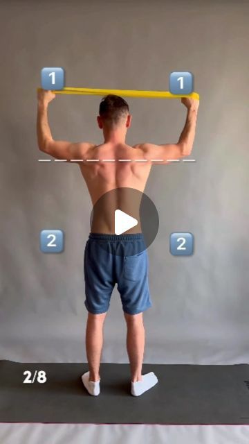 a man standing on top of a yoga mat holding a bar over his head and shoulders