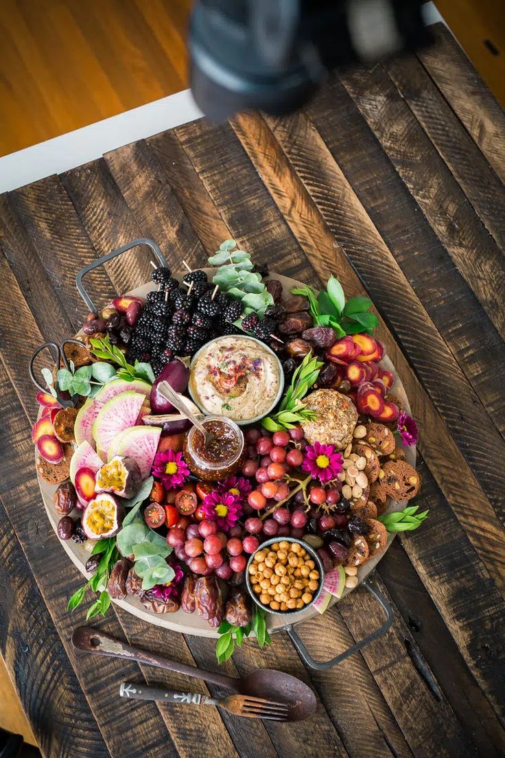 a platter filled with fruit and nuts on top of a wooden table