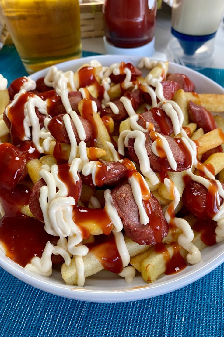 a white plate topped with french fries covered in ketchup and mayonnaise