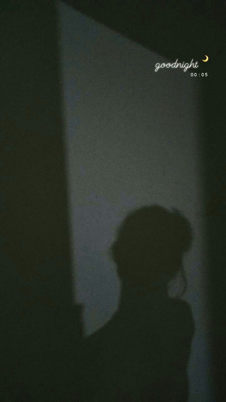 the shadow of a person standing in front of a wall