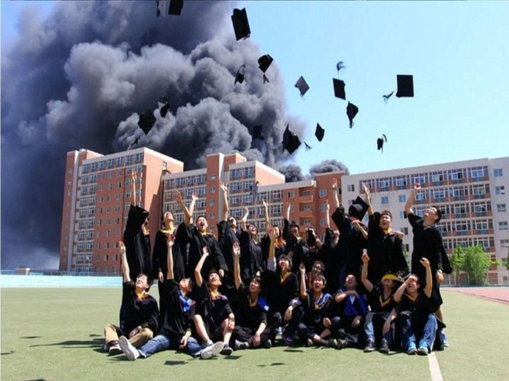 a group of people standing on top of a field with graduation caps in the air