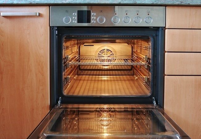 an oven with the door open and it's light on, in a kitchen