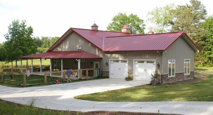 a large house with a red roof in the middle of a grassy area next to trees