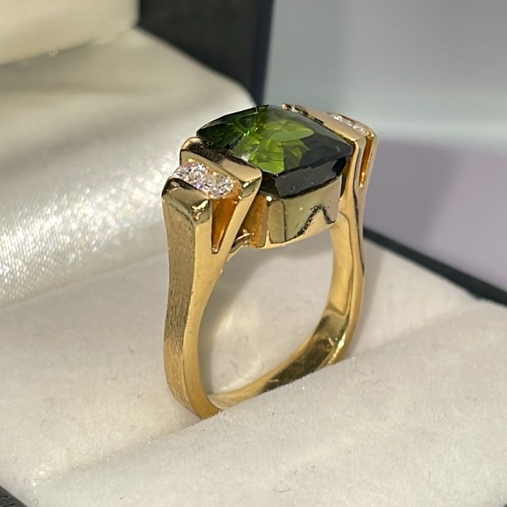 Stunning, One Of A Kind, Vintage Estate Ring. Substantial And Modern. Solid 18k Yellow Gold. Natural Green Tourmaline And Diamonds. Features A Fancy, Abraded, Cushion Cut Green Tourmaline. Moderate Hue And Intensity, Measuring 9.35 Mm X 8 Mm In Channels Setting. Sides Feature Four Natural, Round, Brilliant Cut Diamonds. Estimated Color G H , And Vs To Si Clarity. Estimated .28 Tcw. Please See All Photos For Details. Exceptionally Well Made. Very Rare Opportunity. I Don’t Need To Sell. Price Is Final, No Trades. Elegant Tsavorite Gemstones For Anniversary, Luxury Yellow Gold Peridot Jewelry, Elegant Emerald-cut Tourmaline Ring, Elegant Emerald Cut Tourmaline Ring, Elegant Emerald Cut Tourmaline Jewelry, Luxury Tsavorite Gemstones For Anniversary, Baguette Cut Tourmaline Jewelry For Weddings, Elegant Tourmaline Diamond Ring With Accent Stones, Formal Peridot Diamond Ring In Yellow Gold