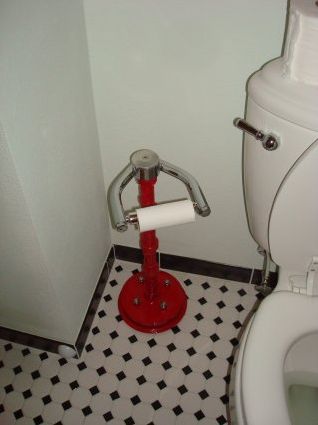 a white toilet sitting in a bathroom next to a red trash can