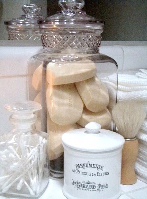 a glass jar filled with lots of white soap next to other items on a counter