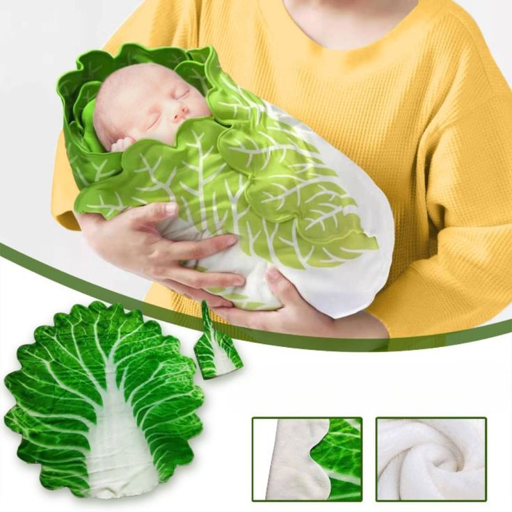 a woman holding a baby in her arms with green leaves on it's wrap