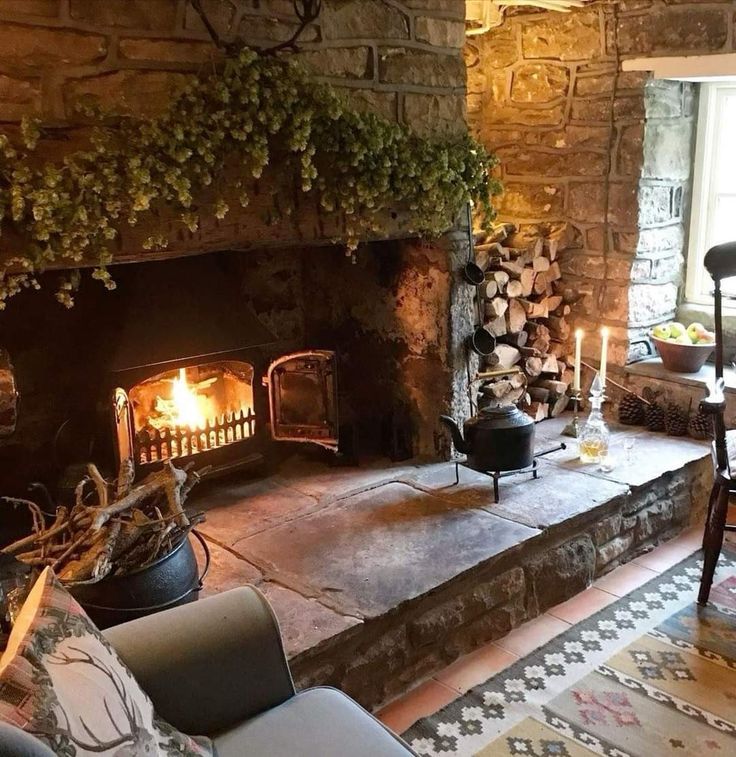 a living room filled with furniture and a fire place in the middle of a stone fireplace