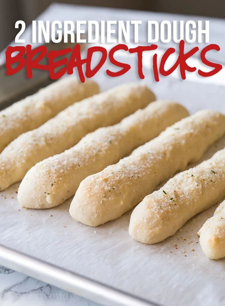 six breadsticks are lined up on a baking sheet with the words, 2 ingredient dough breakfast sticks