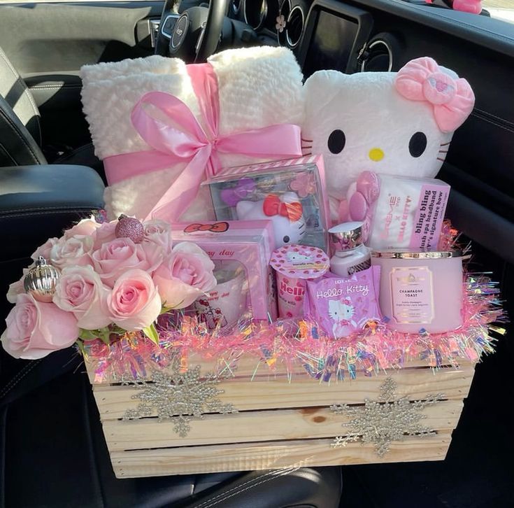 a hello kitty gift basket in the back seat of a car filled with pink roses