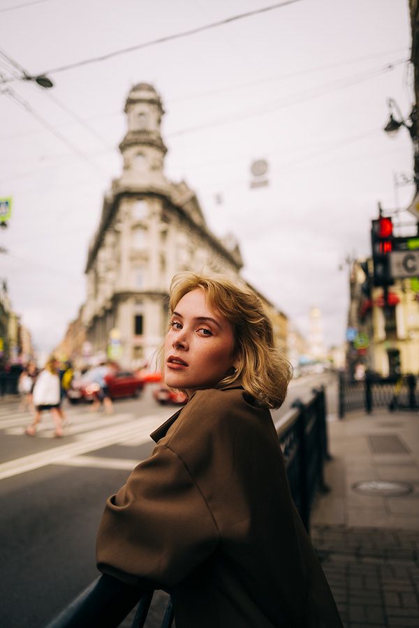 a woman leaning on a rail in front of a building