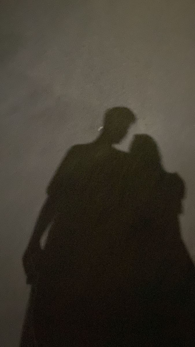 the shadow of two people standing next to each other