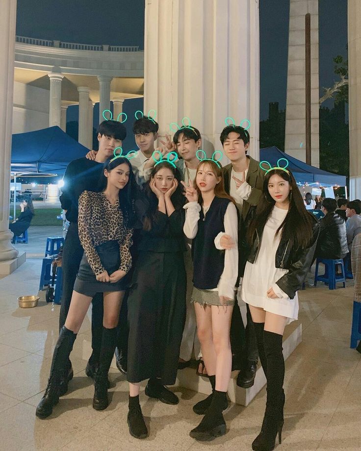 a group of people standing next to each other in front of a building at night