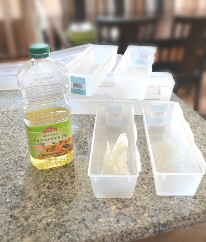 several plastic containers filled with food sitting on top of a granite counter next to a bottle of olive oil