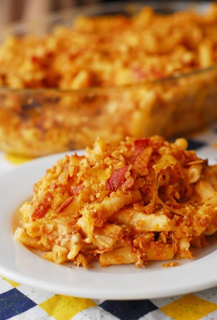 a white plate topped with macaroni and cheese next to a casserole dish