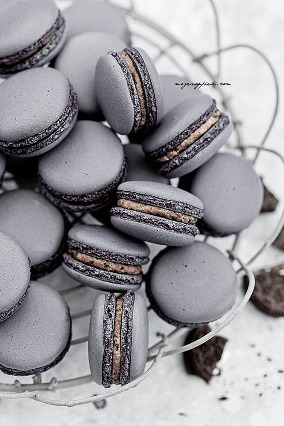 a basket filled with grey macaroons on top of a table