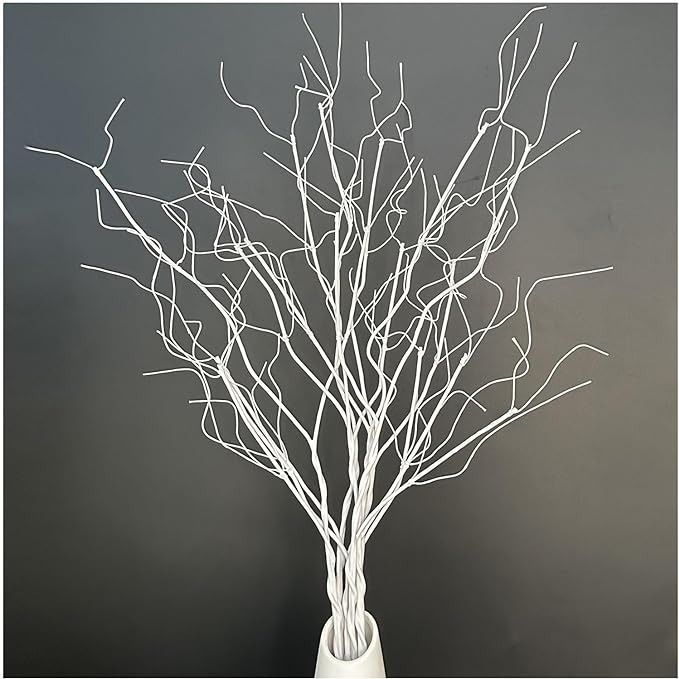 a white vase filled with branches on top of a table