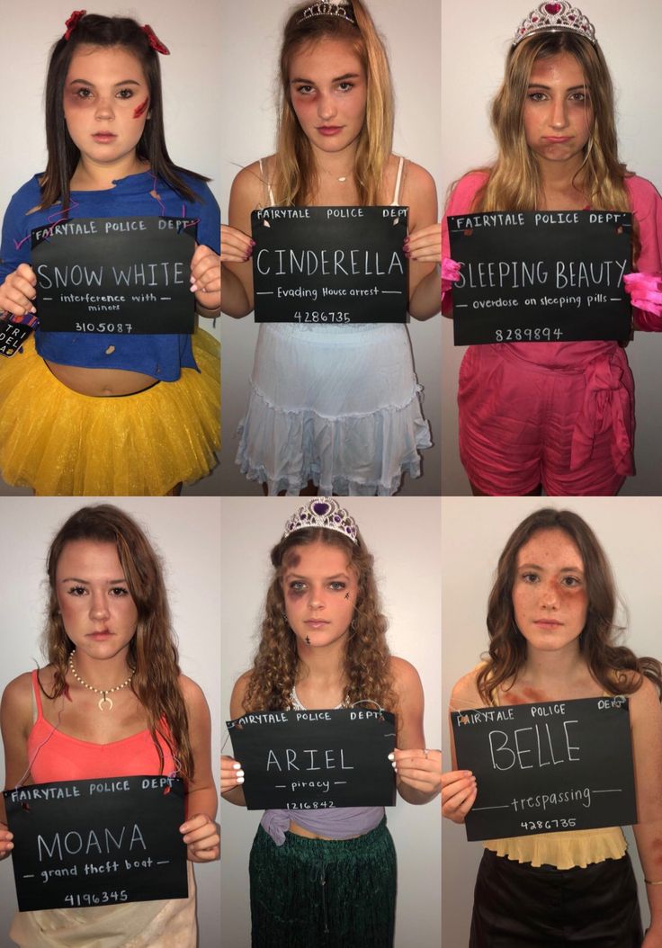 four girls in costumes holding up signs with words on them