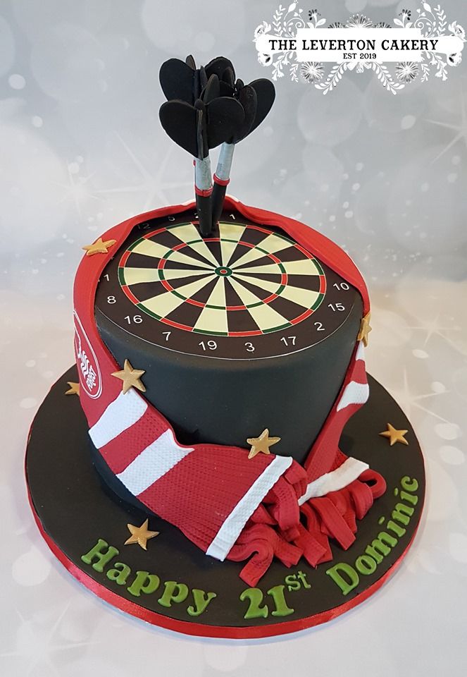 a dart themed birthday cake with darts on top