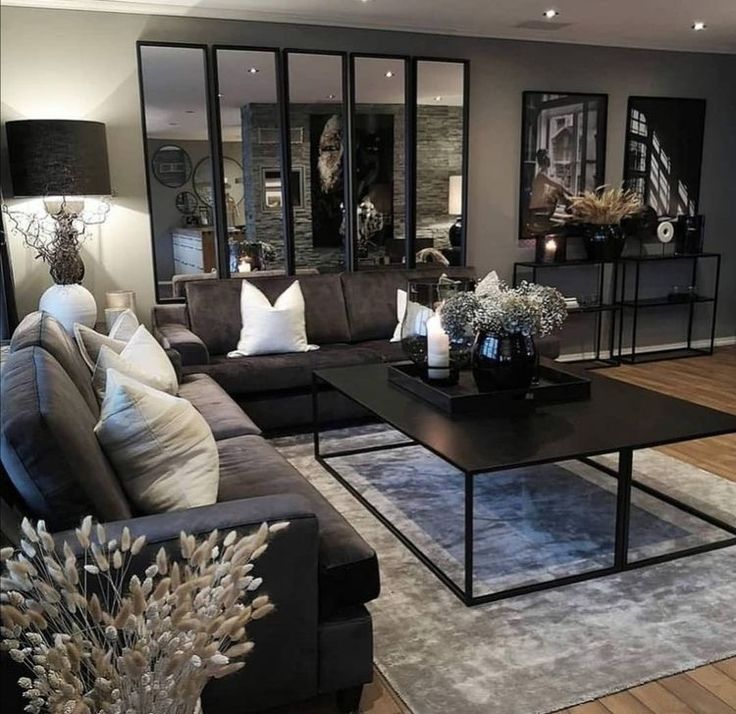 a living room with couches, tables and mirrors on the wall in it's center