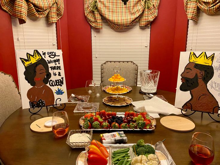 a wooden table topped with plates of fruit and veggies next to two cards