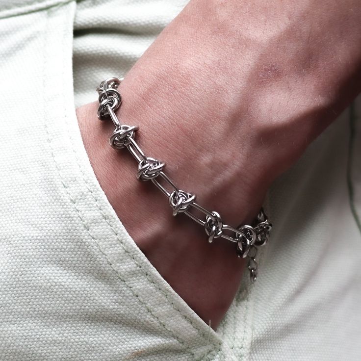 Show off your grunge style with the Gluck Silver Knott Chain Adjustable Bracelet. It features a knott chain with a lobster clasp for easy adjustments, allowing you to wear it snugly around your wrist for a comfortable fit. knott chain stainless steel 6.5 inches adjustable to 8.5 inches Silver Chain Bracelets, Silver Chain Bracelet For Men, Grunge Jewelry With Adjustable Chain For Streetwear, Modern Grunge Aesthetic, Punk Stainless Steel Jewelry With Adjustable Chain, Men’s Bracelet, Mens Silver Chain Bracelet, Grunge Bracelets, Punk Jewelry With Adjustable Stainless Steel Chain