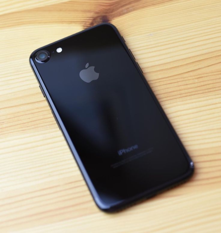 an iphone sitting on top of a wooden table