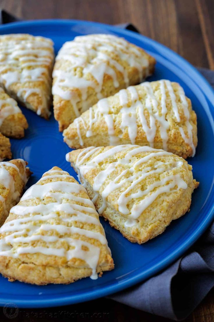 a blue plate topped with scones covered in frosting