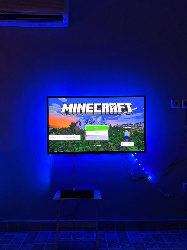 a flat screen tv sitting on top of a table in front of a blue wall