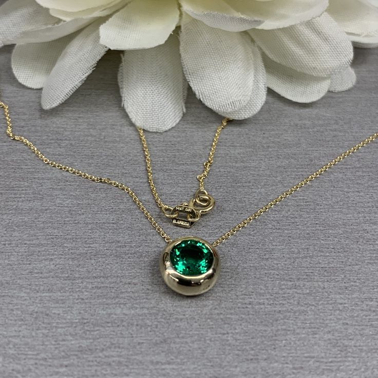 "The pendant pictured is a lab created emerald #6750 Video shows 14k White Gold -Approximate total carat weight: approx. 1.00ctw diamond equivalent -Center Stone Size: 6.5mm - approx. 1.00ct diamond equivalent -Center Stone Shape: round -Gem Type: lab created emerald -Stone Clarity: VS2 -Stone Color: lively rich green -Moh's Scale: 8.5 hardness -Metal Type and Purity: 14k yellow gold -Setting: bezel set floating necklace -Chain: delicate 14k gold chain / heavier option with lobster claw availabl Formal Emerald Necklace With Bezel Setting, Formal Round Emerald Necklaces, Classic Emerald Pendant Necklace In Bezel Setting, Classic Emerald Pendant Necklace With Bezel Setting, Classic Bezel Set Emerald Pendant Necklace, Classic Emerald Necklaces With Bezel Setting, Formal Round Gemstone Solitaire Necklace, Formal Round Emerald Necklace Fine Jewelry, Formal Round Emerald Necklace