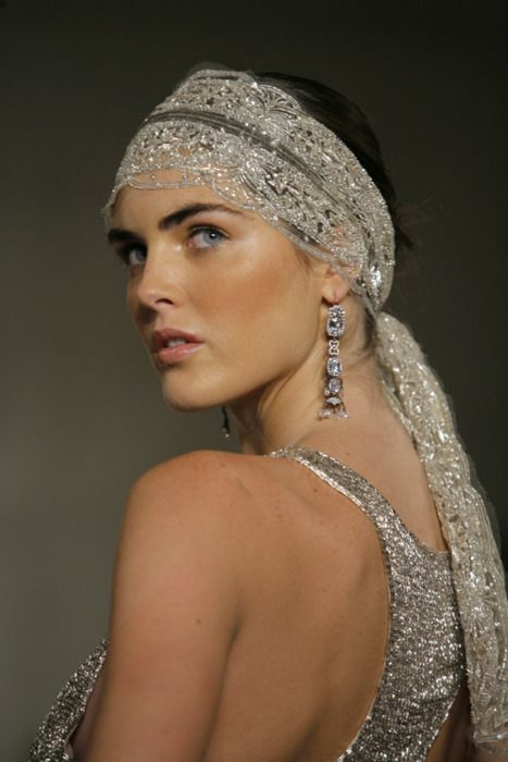 a woman wearing a silver dress and head scarf