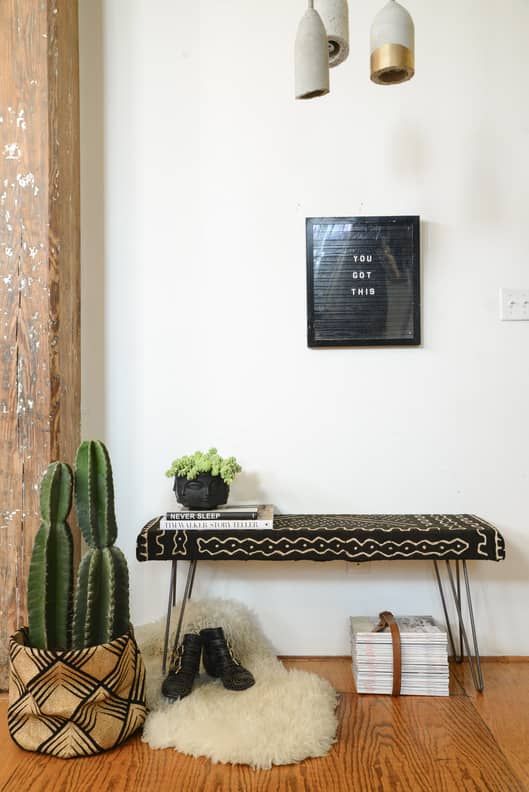 a room with a bench, cactus and other items on the floor in front of it